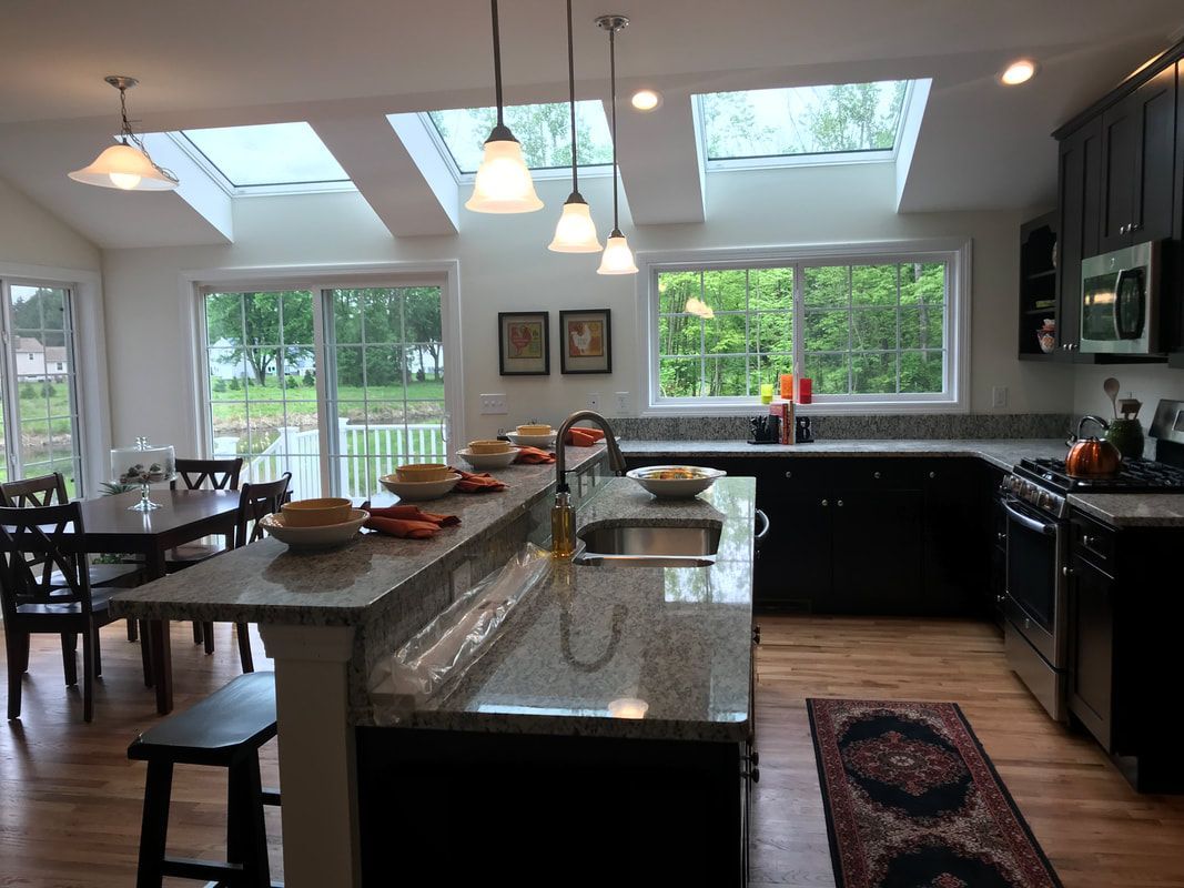 A kitchen with a table and chairs and a skylight