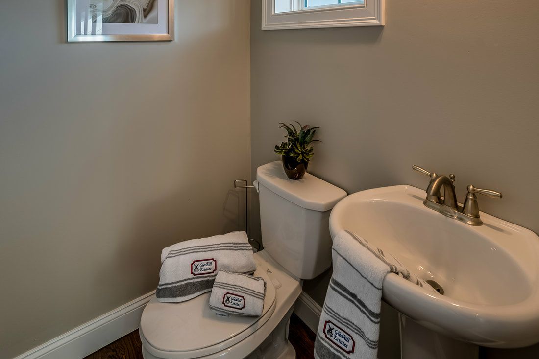 A bathroom with a toilet , sink and towels.