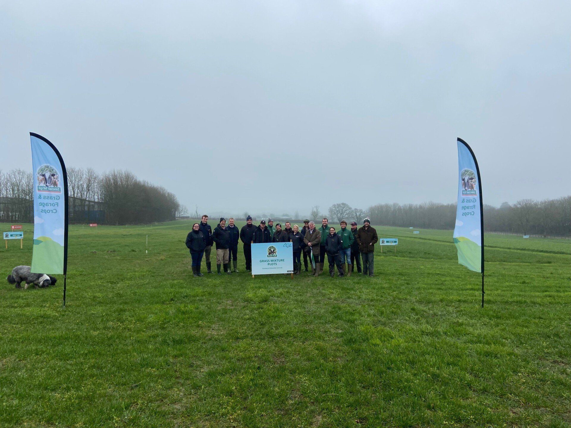 a group of people standing in a grassy field with a sign that says ' open farm day ' on it