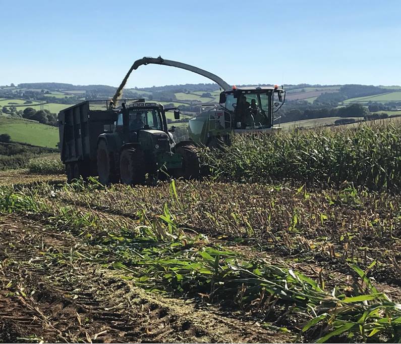 a tractor is in a field with a trailer attached to it
