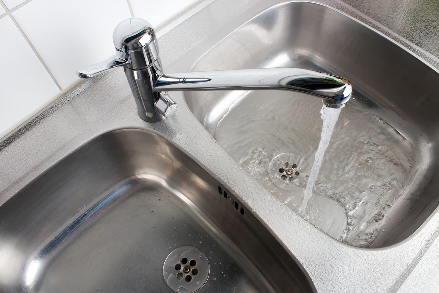 A Stainless Steel Kitchen Sink With Water Running From the Faucet — John Day Plumbing in Darwin, NT