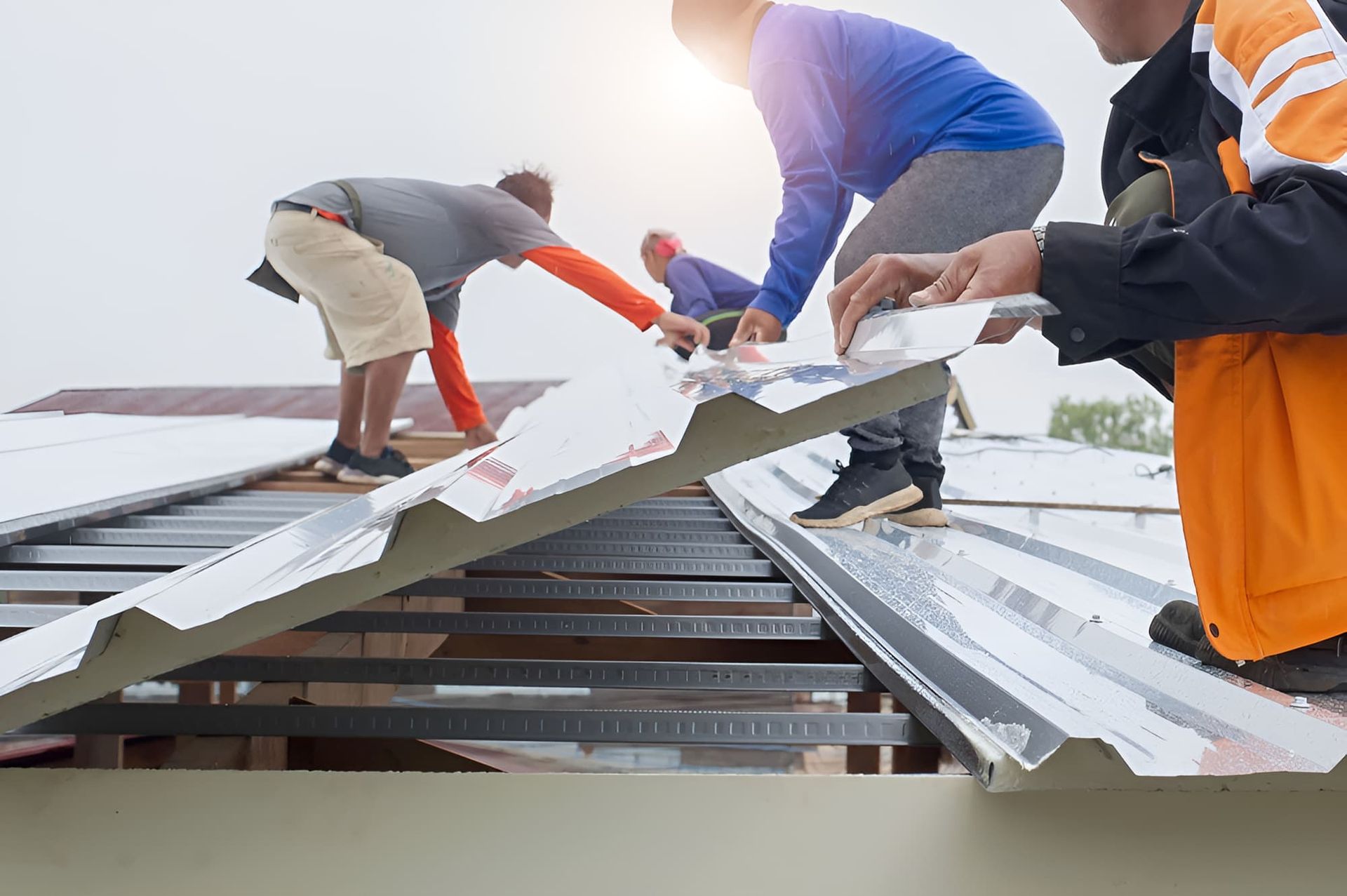 A Group of Men Are Working on a Metal Roof — John Day Plumbing in Marlow Lagoon, NT