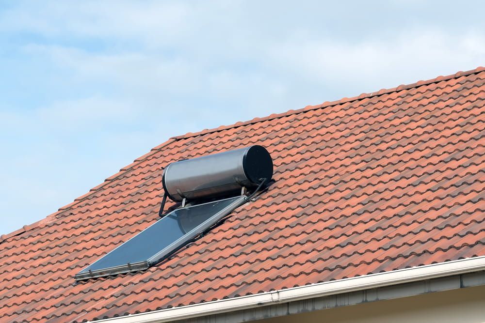 A Solar Water Heater Is Mounted on The Roof of A House — John Day Plumbing in Marlow Lagoon, NT
