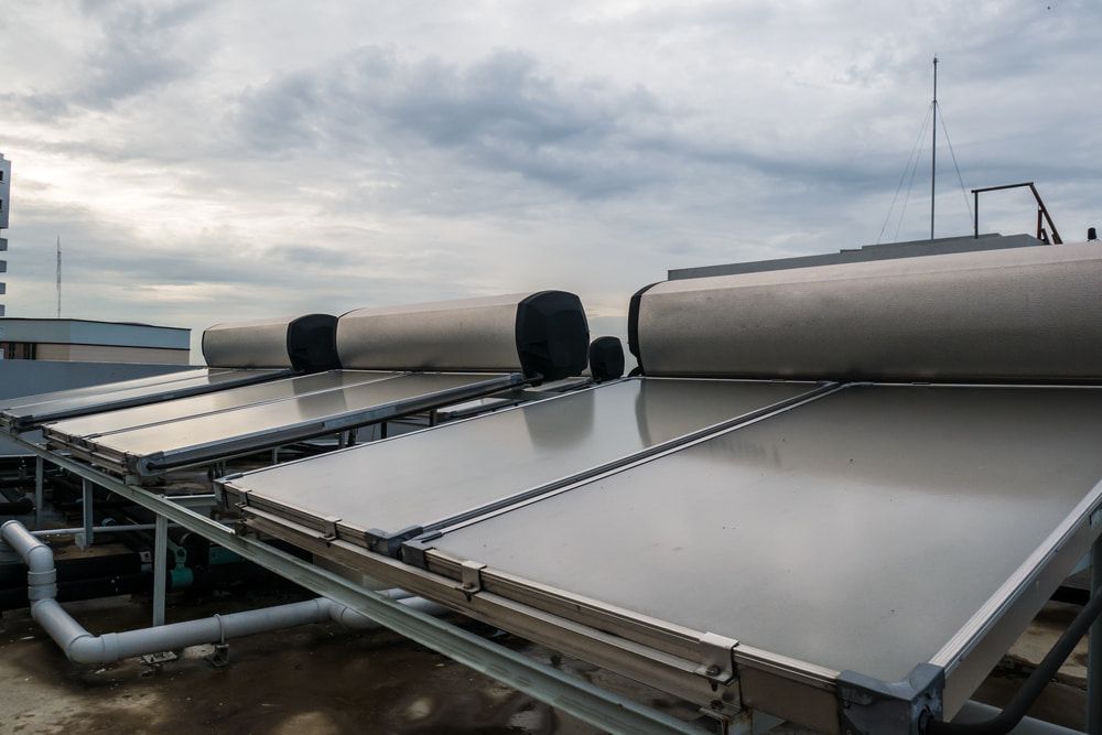 A Row of Hot Water Solar Panels on The Roof of A Building — John Day Plumbing in Marlow Lagoon, NT