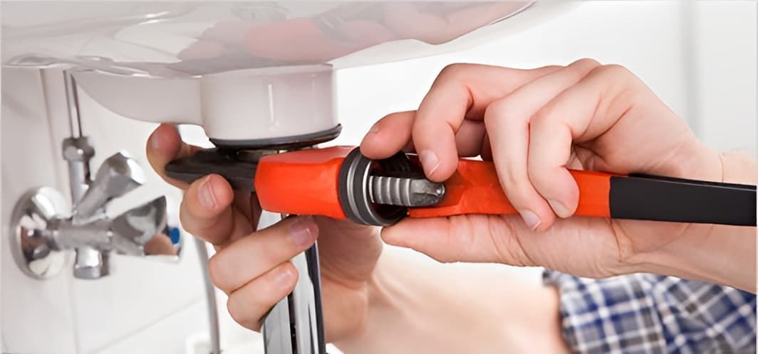 A Person is Fixing a Sink With a Wrench — John Day Plumbing in Marlow Lagoon, NT