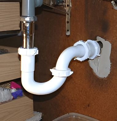 A White Pipe is Attached to a Brown Wall — John Day Plumbing in Marlow Lagoon, NT