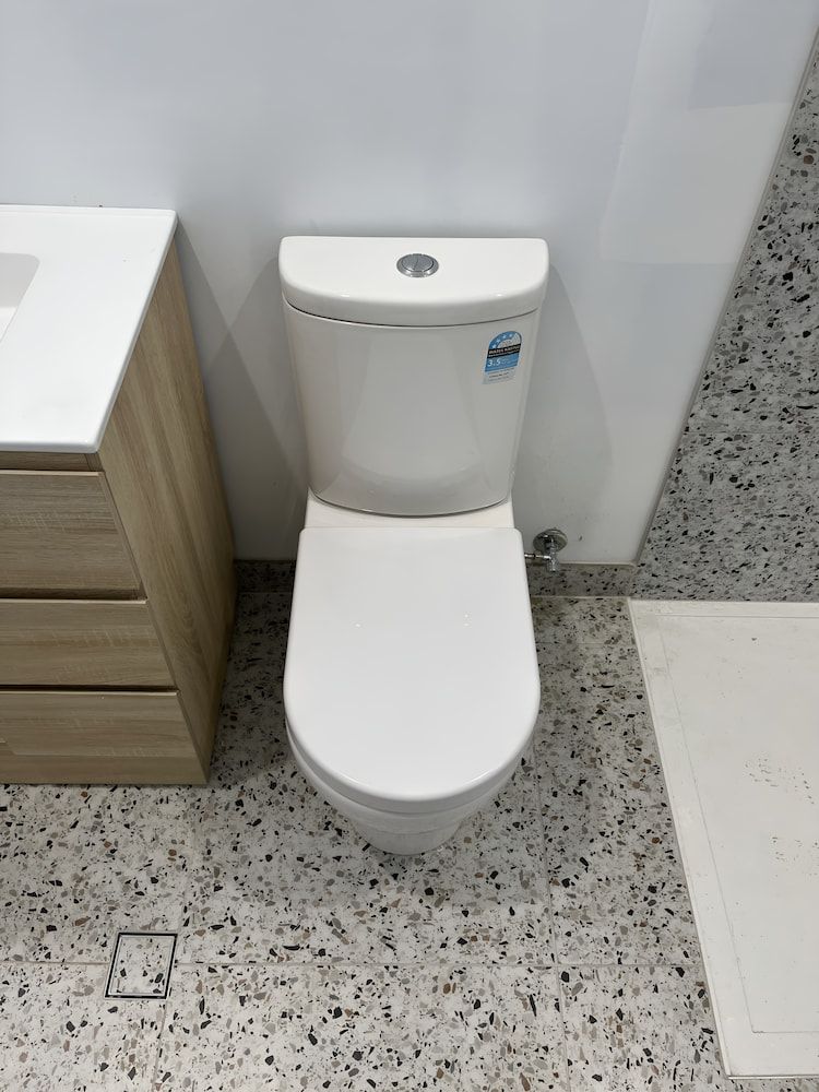 A Toilet is Sitting in a Bathroom Next to a Sink — John Day Plumbing in Marlow Lagoon, NT