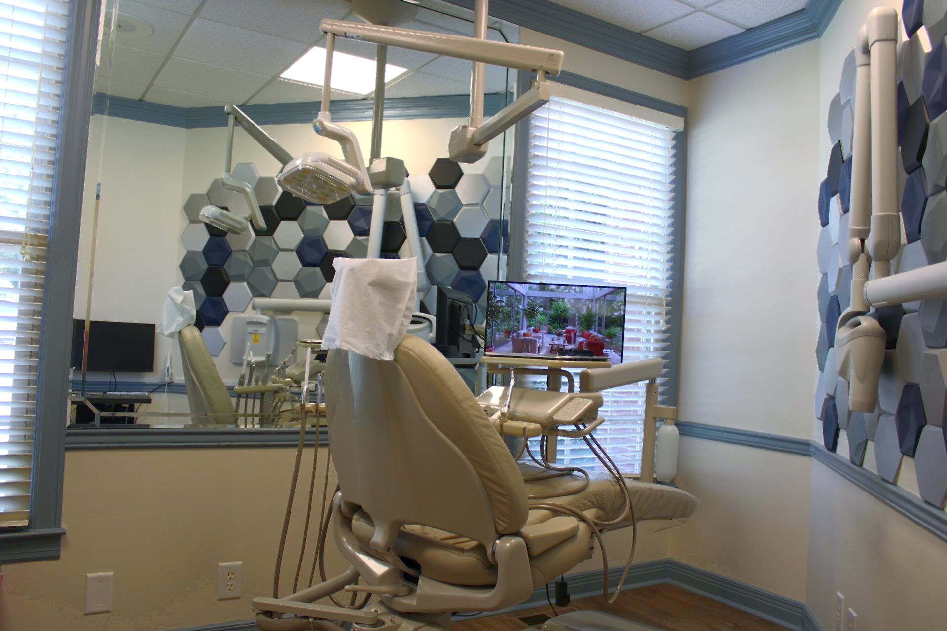 A dental assistant and dentist attending to a patient in a modern dental office.