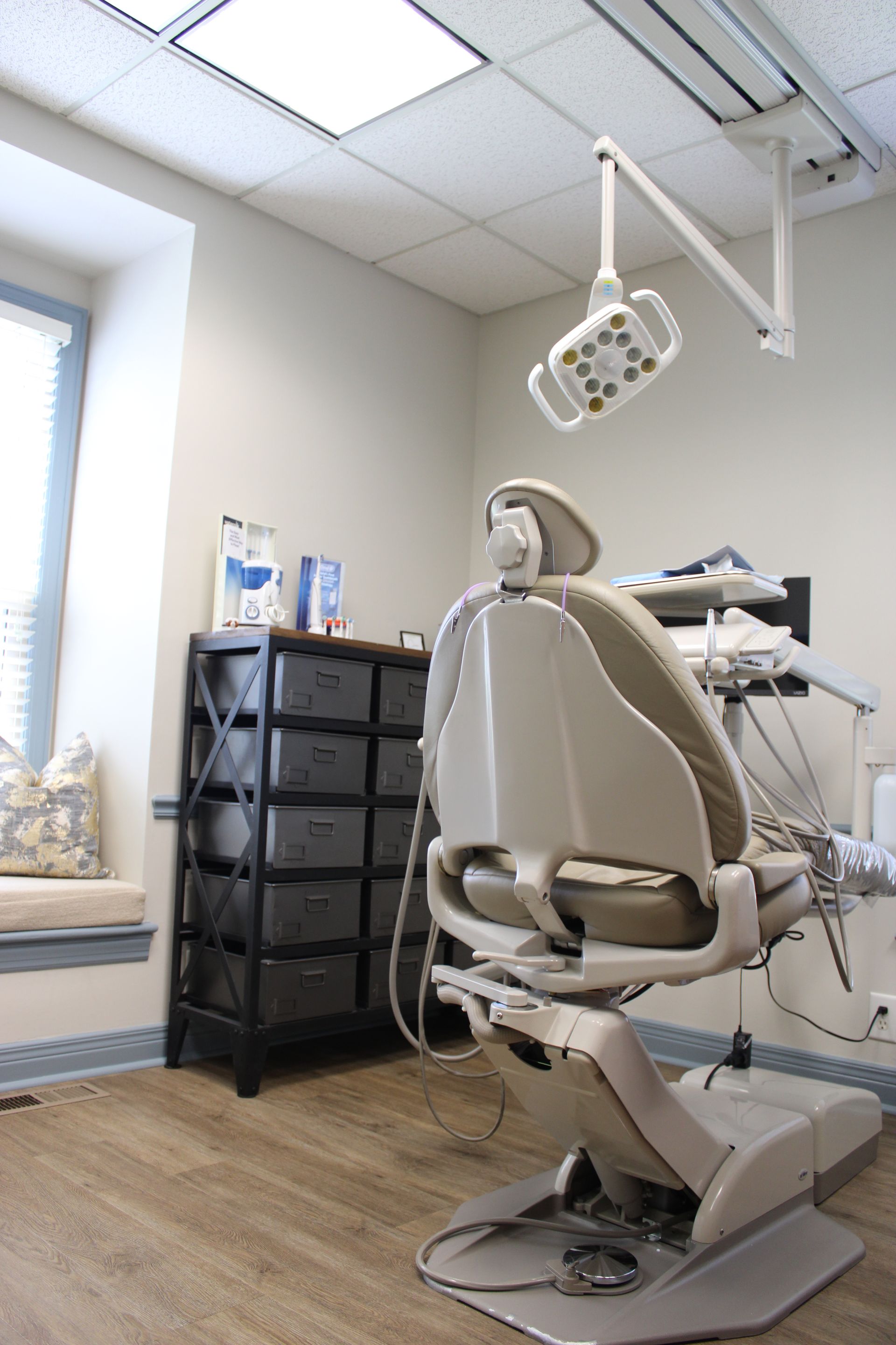 A dental assistant and dentist attending to a patient in a modern dental office.
