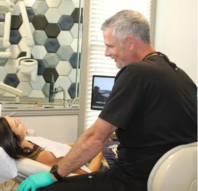 A dental assistant and dentist attending to a patient in a modern dental office.