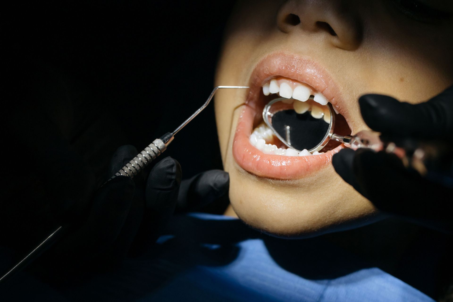 A dental assistant and dentist attending to a patient in a modern dental office.