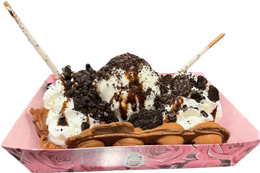 Ice cream sundae in a pink tray with chocolate sauce, whipped cream, cookies, and wafer sticks