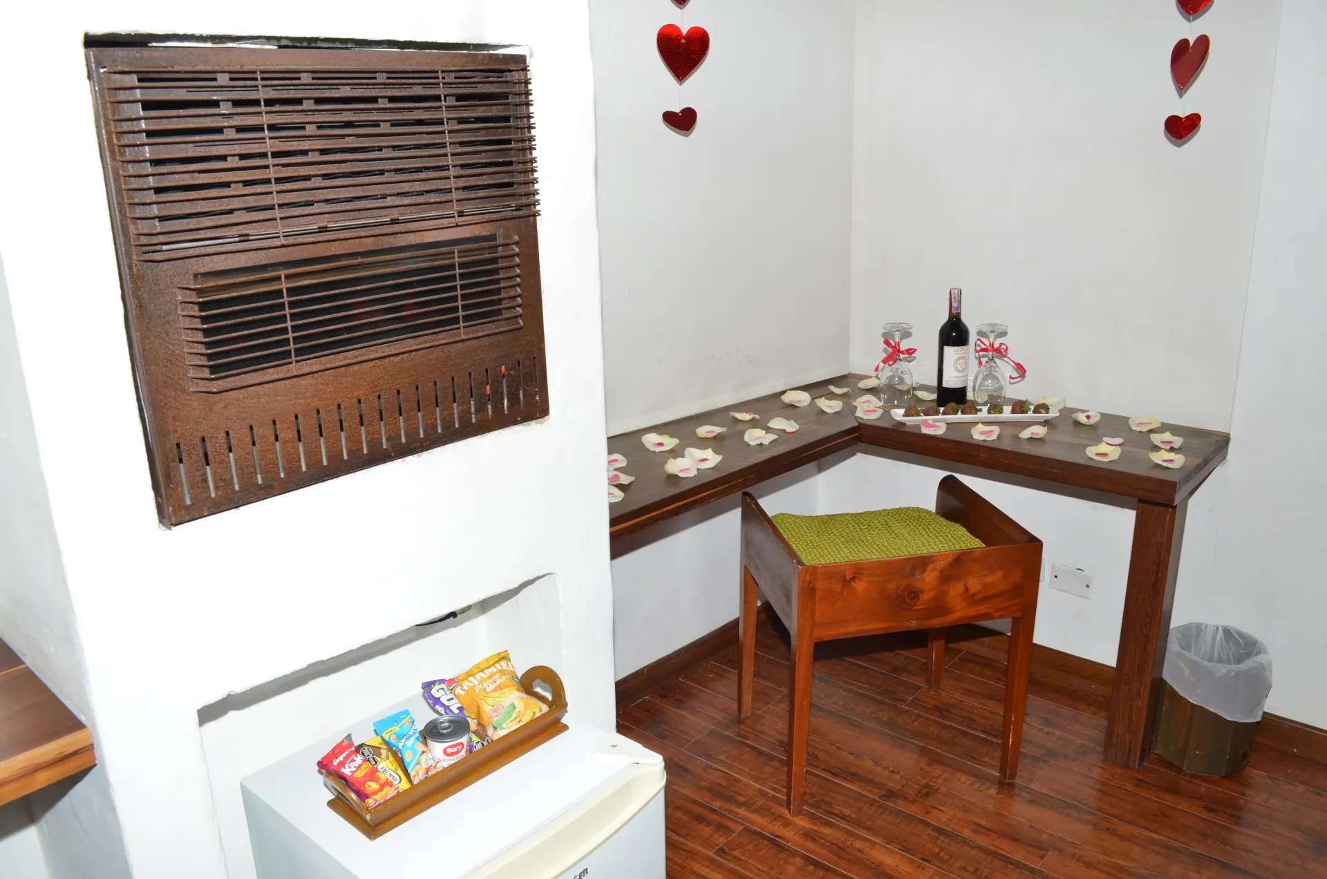 Cozy room with grill, desk set for two, snacks, and heart decorations. Brown tones.