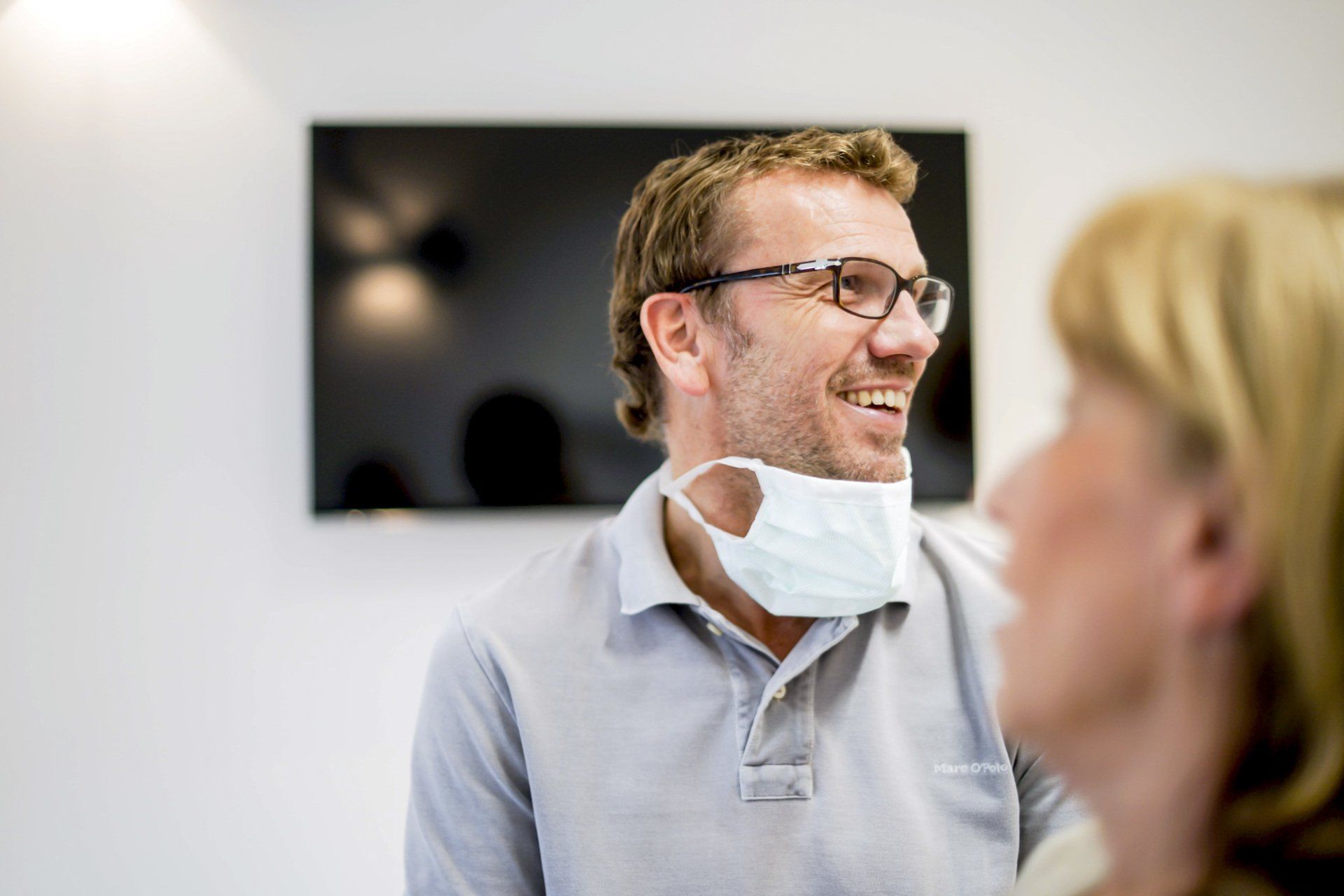 Dr. Johan de Jonge with mask and glasses talks to a woman.
