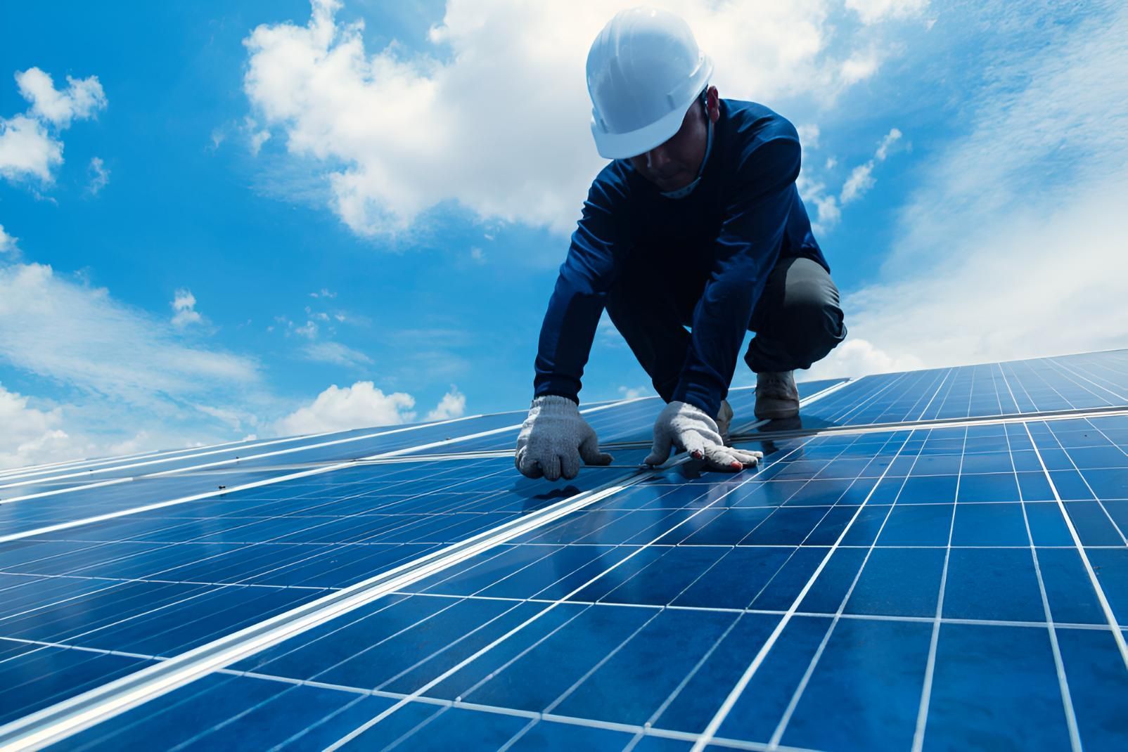 A Man is Working on a Solar Panel on Top of a Roof — Power & Data Support Services In Weipa, QLD