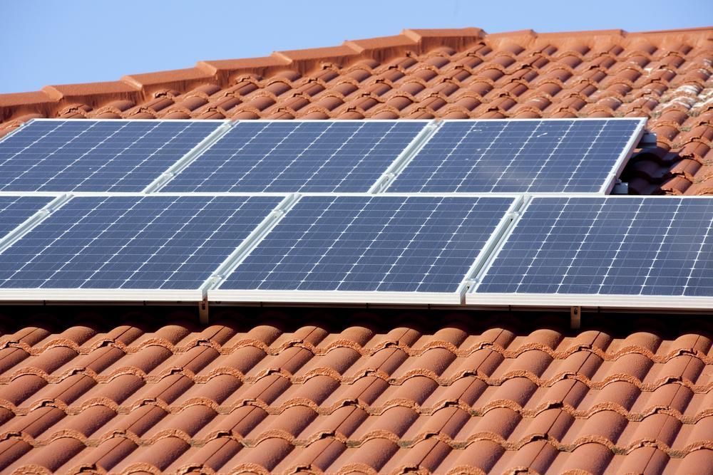A Row of Solar Panels on a Tiled Roof — Power & Data Support Services In Mareeba, QLD