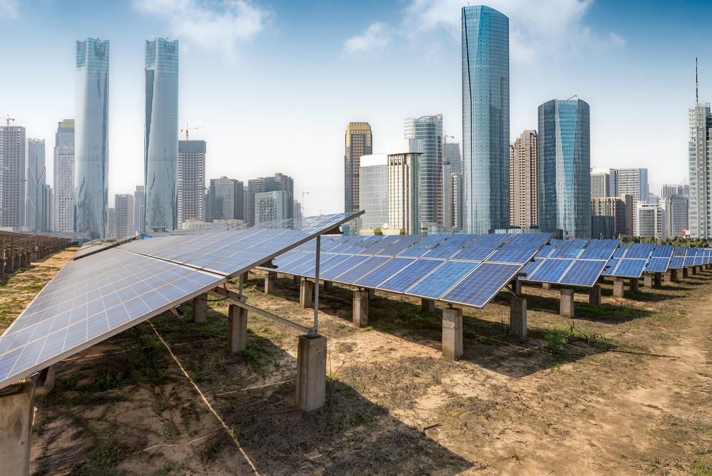 A Row of Solar Panels With a City Skyline in the Background — Power & Data Support Services In Tablelands, QLD