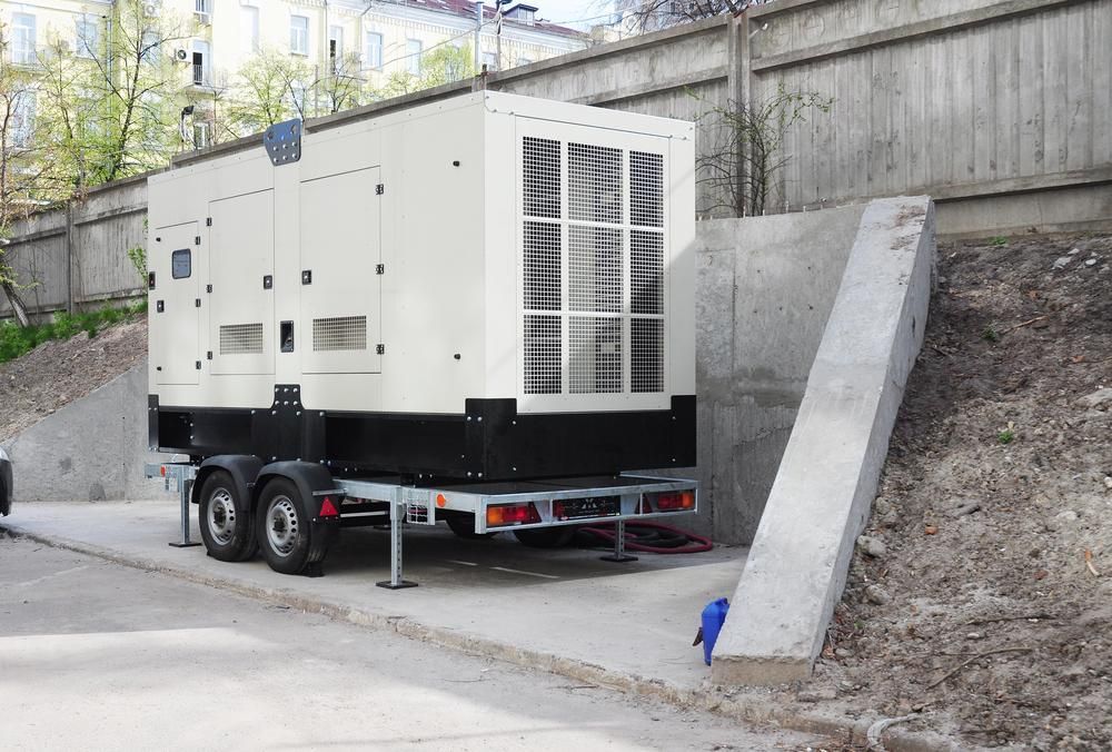 A Large Generator on a Trailer is Parked Next to a Concrete Wall — Power & Data Support Services In Thursday Island, QLD