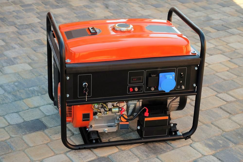 An Orange and Black Generator is Sitting on a Brick Driveway — Power & Data Support Services In Mareeba, QLD