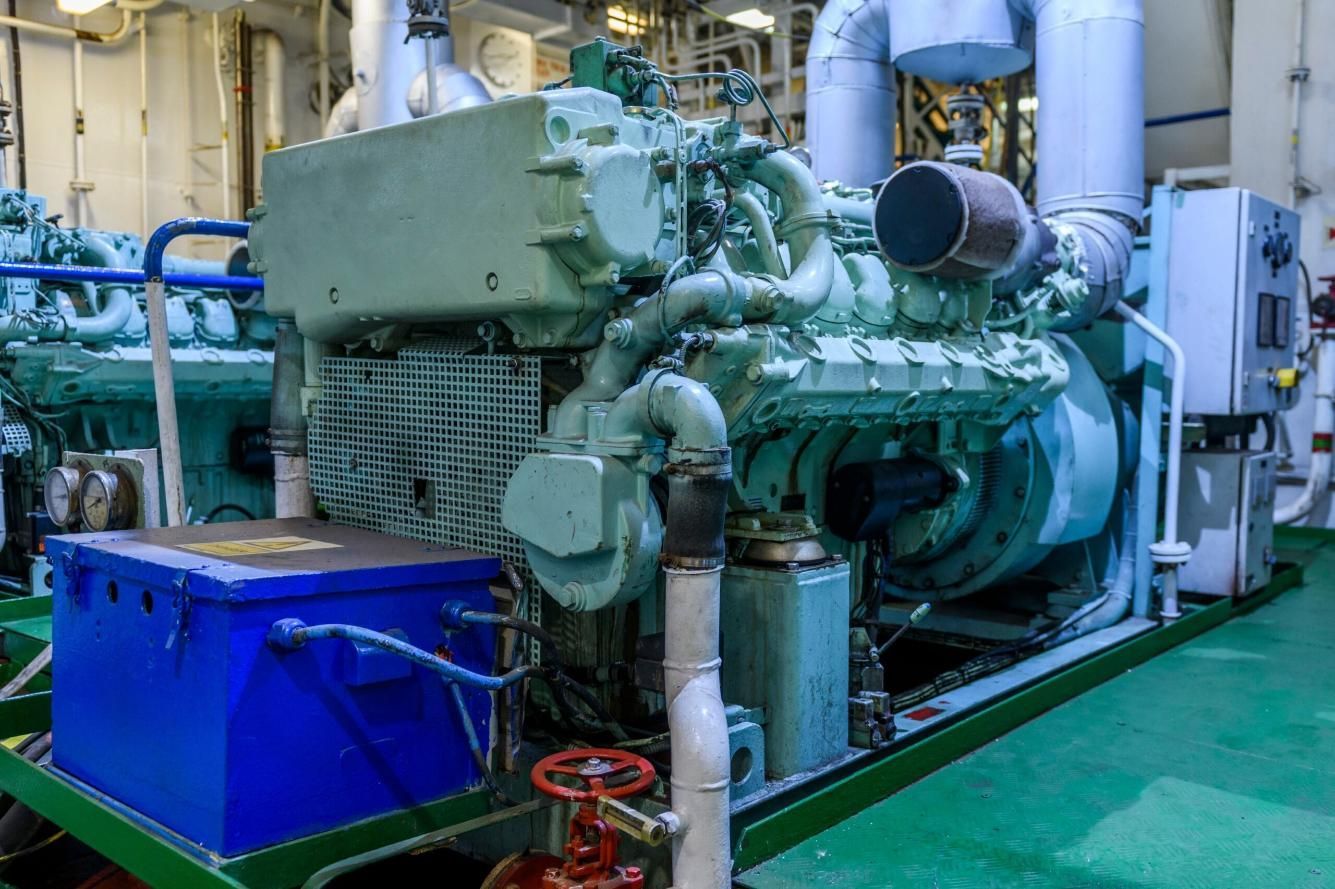 A Large Engine is Sitting in the Engine Room of a Ship — Power & Data Support Services In Tablelands, QLD