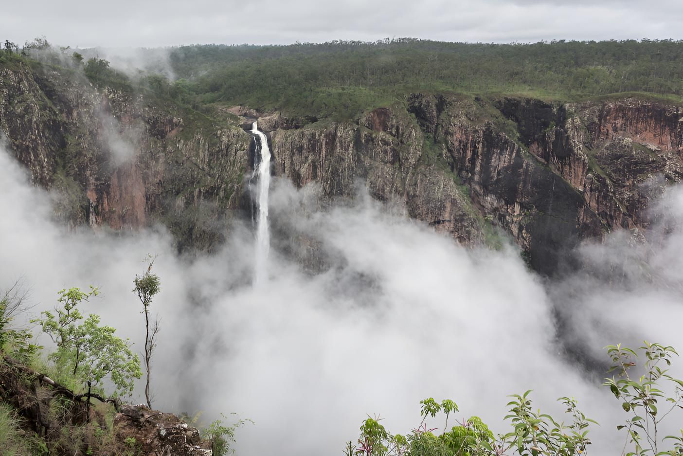 A Waterfall is Surrounded by Clouds in the Middle of a Canyon — Power & Data Support Services In Ingham, QLD