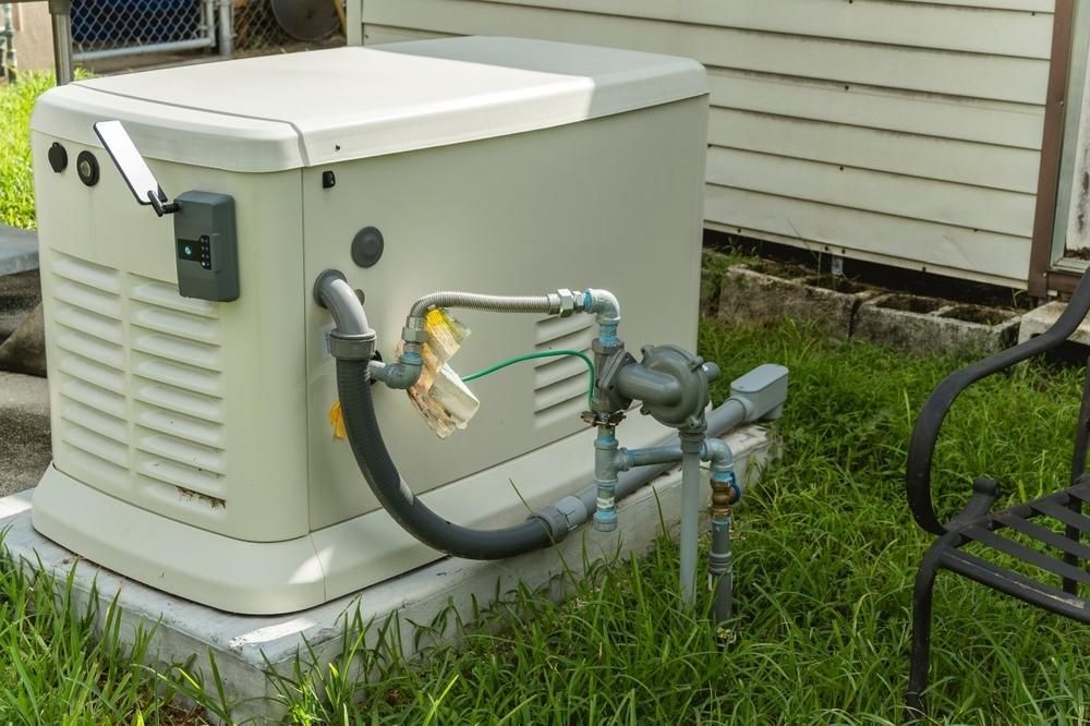 A Generator is Sitting in the Grass in Front of a House — Power & Data Support Services In Tully, QLD