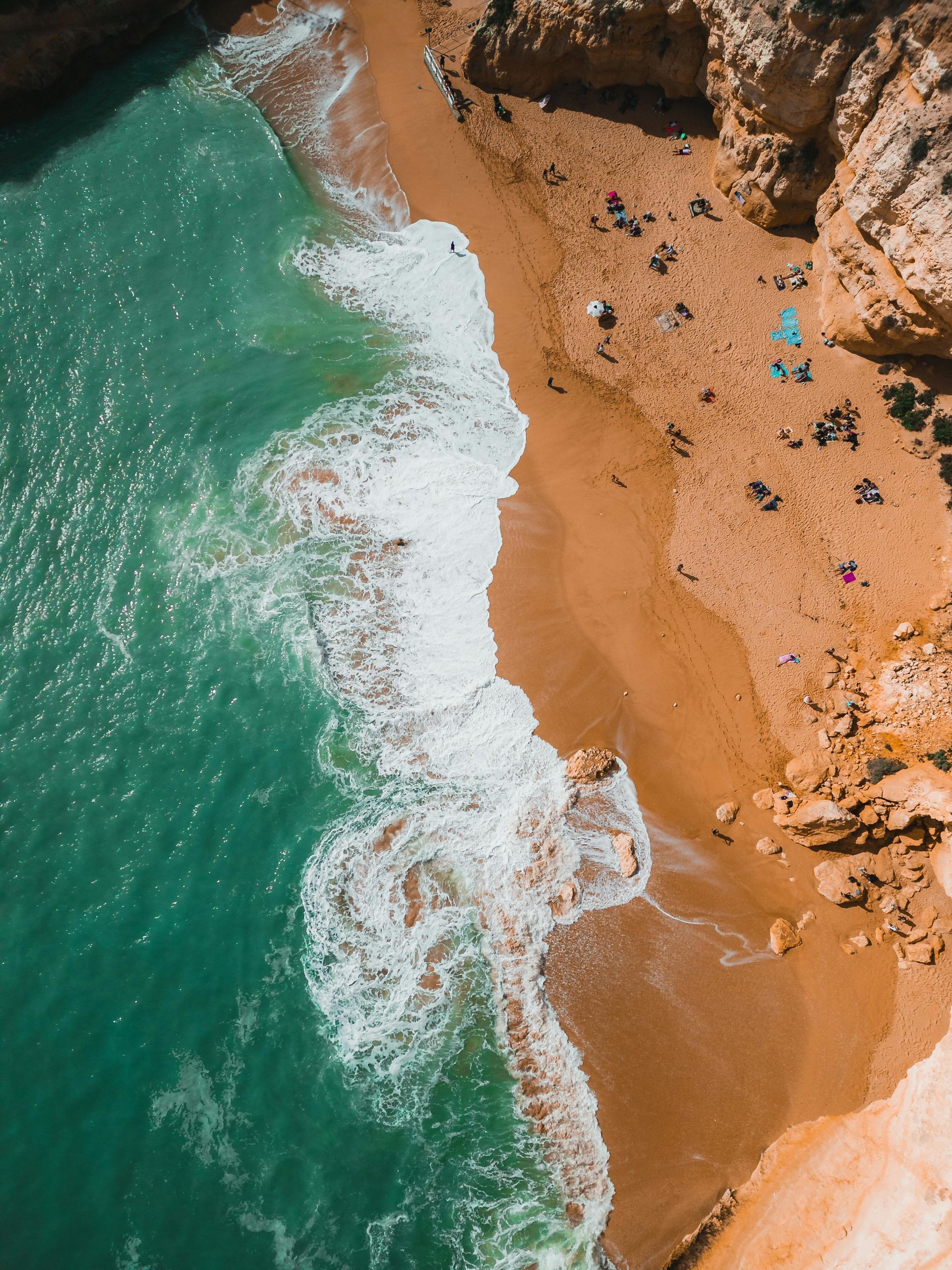 An aerial view of a sandy beach next to a body of water.