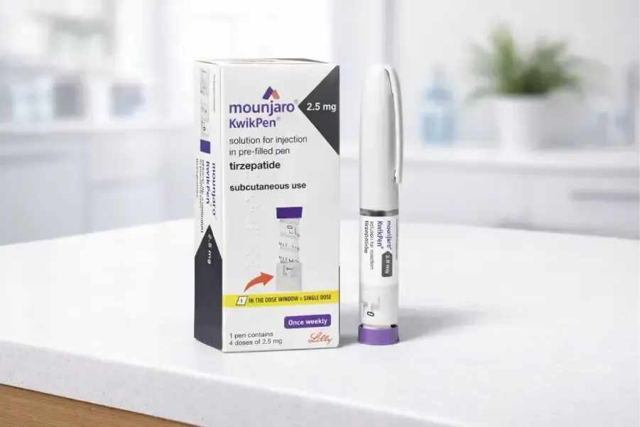 Mounjaro KwikPen and box on a white countertop; box is white and purple; pen is white with a purple cap.
