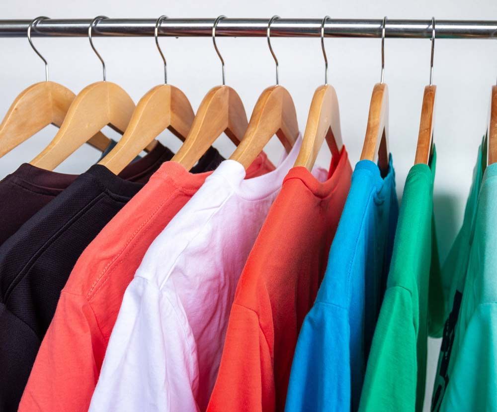 A Row Of Colourful T-shirts Are Hanging On A Rack — Shop Fittings Office Furniture Materials Handling In Gosford, NSW