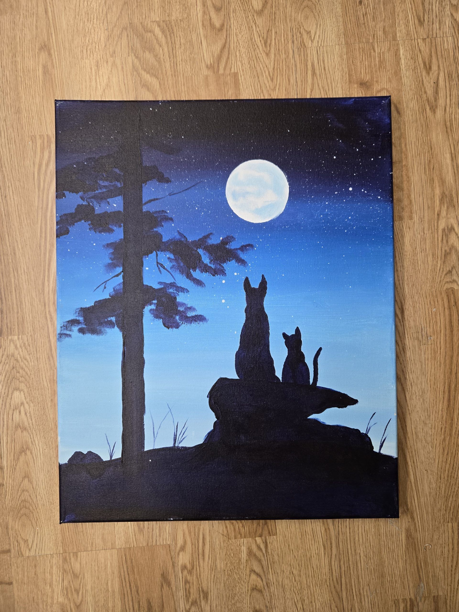 Silhouetted dogs on a rock under a full moon in a starry night sky