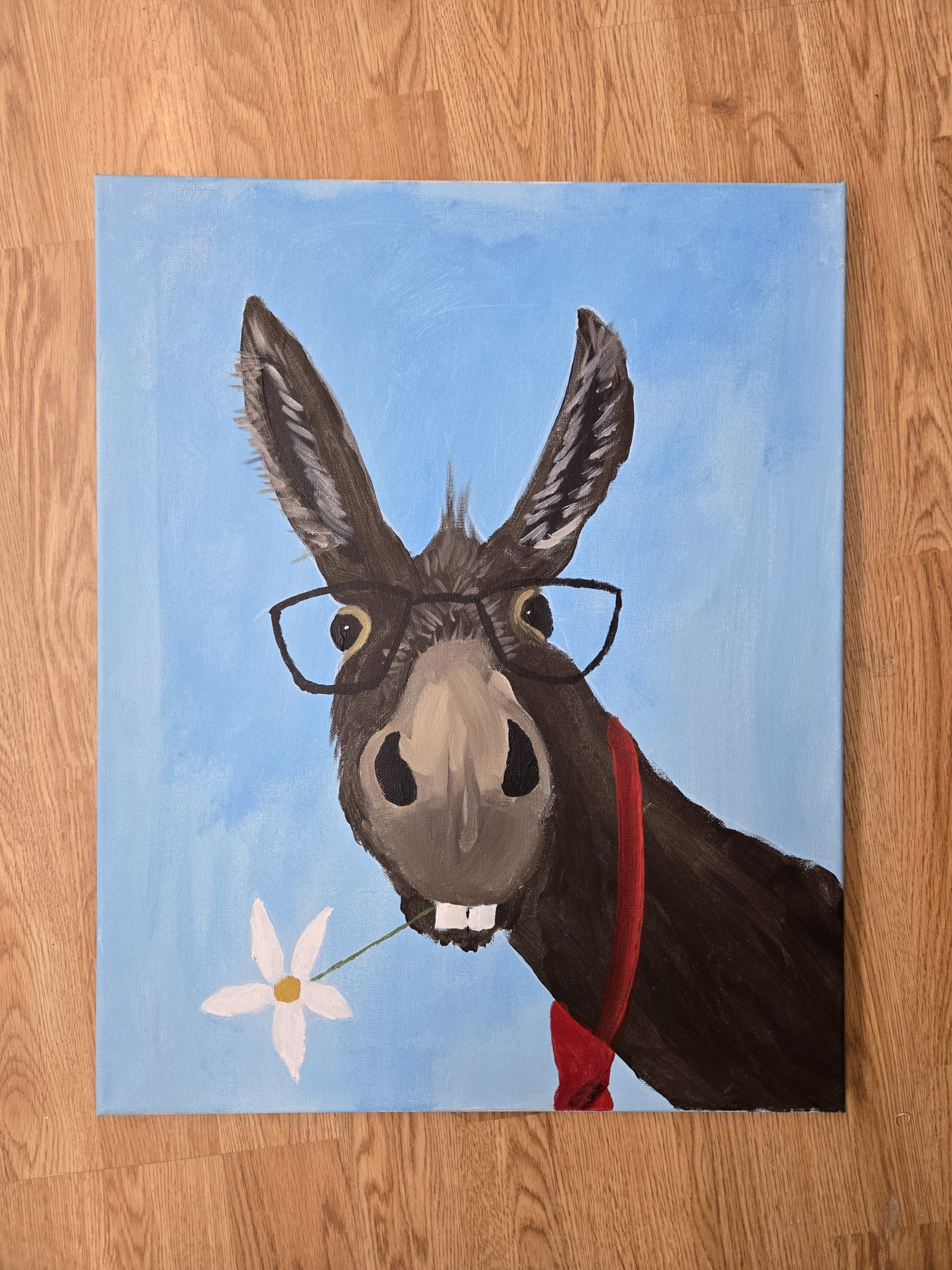 Donkey wearing glasses and a red scarf against a blue sky, with a small white flower nearby.