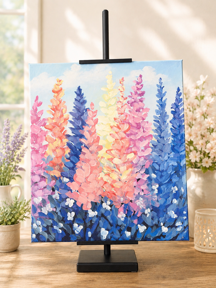 Paintings on easels at a craft fair, including a colorful pumpkin scene and paint palettes on tables