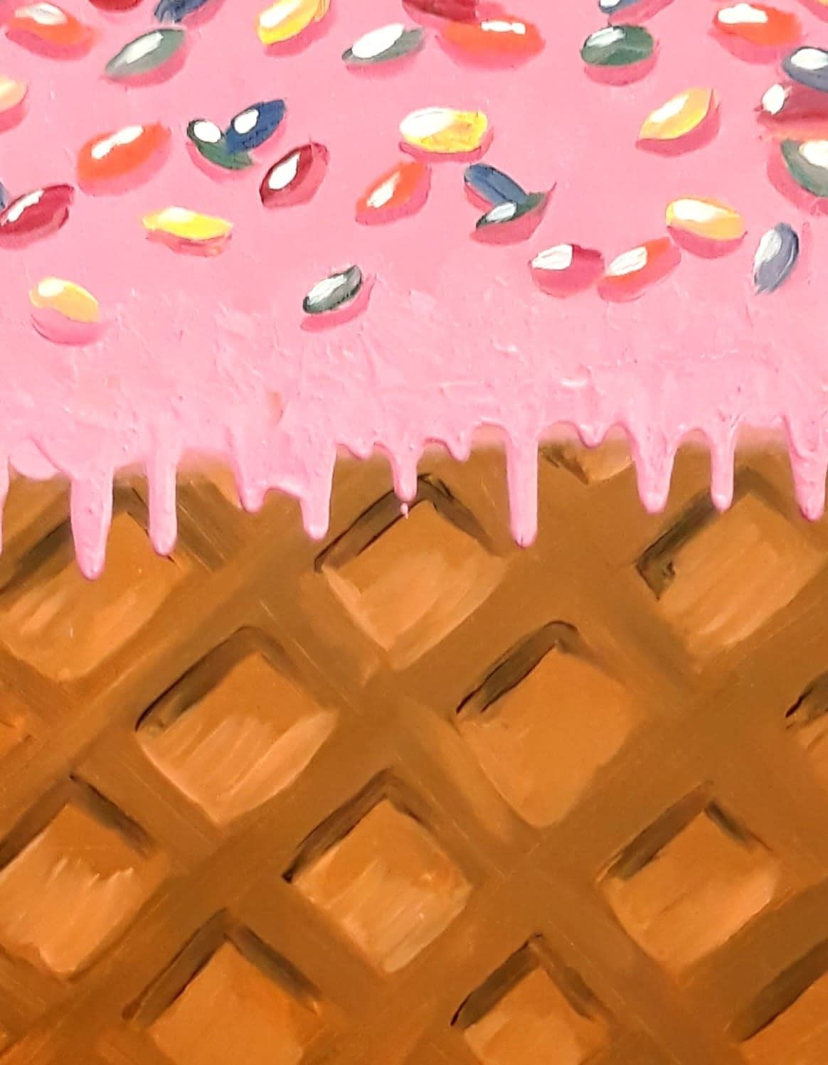 Pink frosted waffle cone with colorful sprinkles against a brown waffle background
