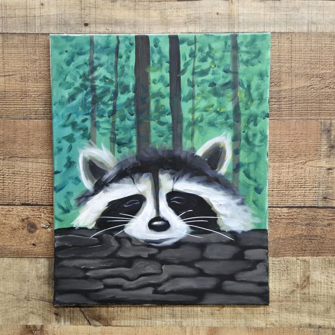 Raccoon peeking over a stone wall in a green forest painting