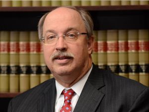 A man in a suit and tie is smiling for the camera.