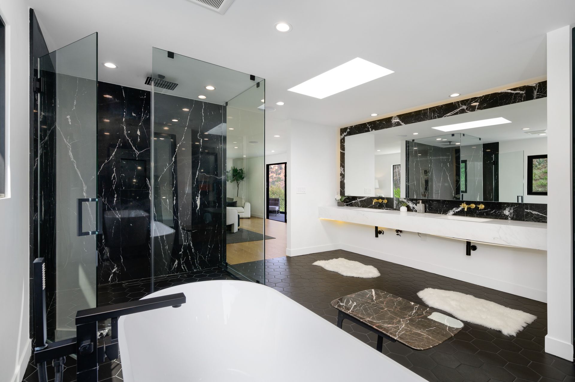 A bathroom with a bathtub , sink , shower and mirrors.