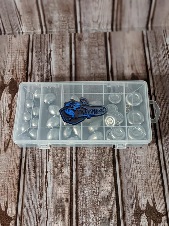 A plastic box filled with fishing weights is sitting on a wooden table.
