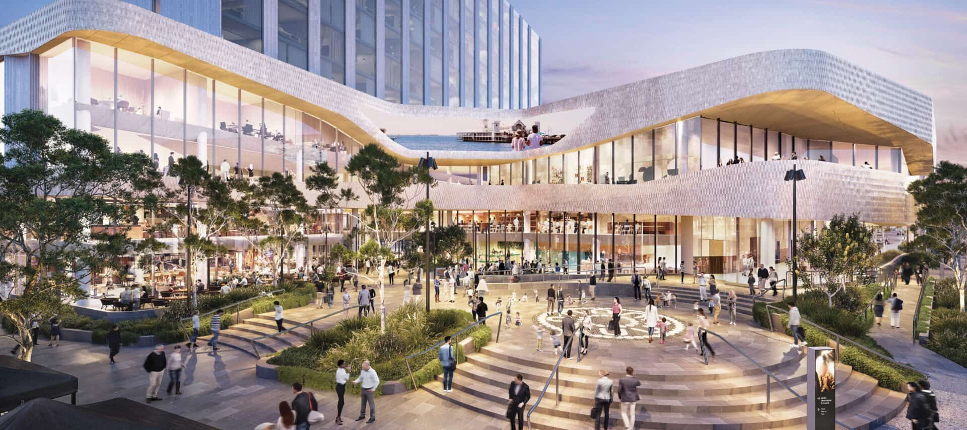 Modern plaza with a curving glass building, trees, steps, and people gathered at dusk.
