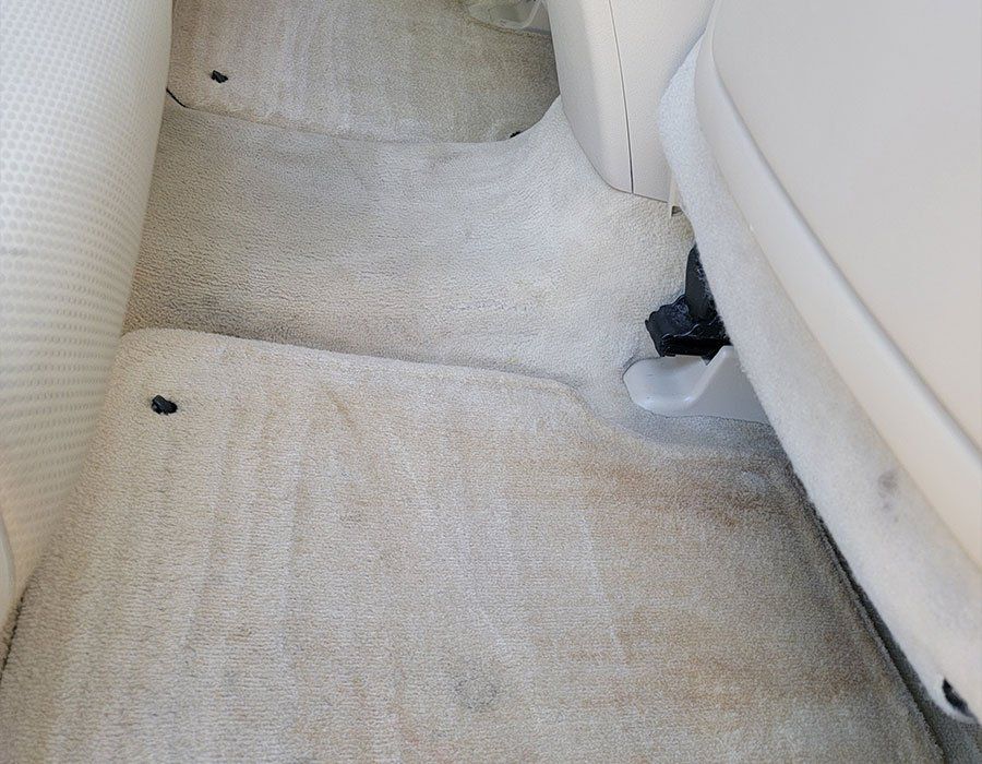 A white carpeted floor in a white car
