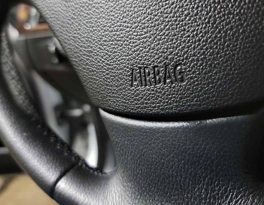 A close up of a car steering wheel with airbag written on it