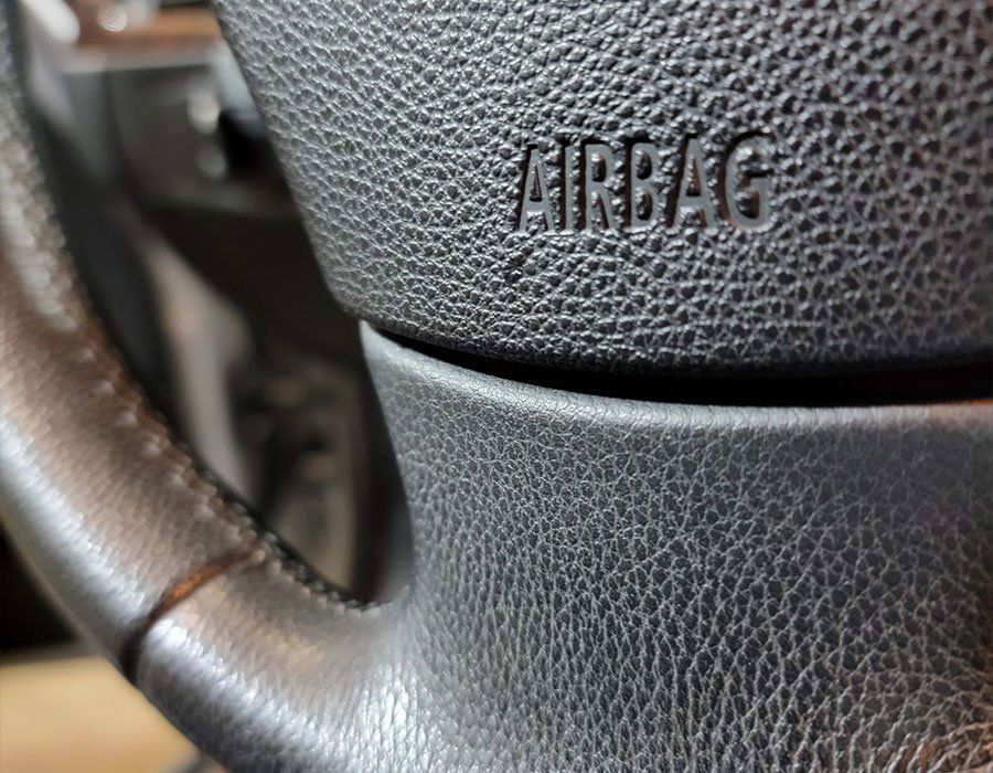 A close up of a car steering wheel with airbag written on it.