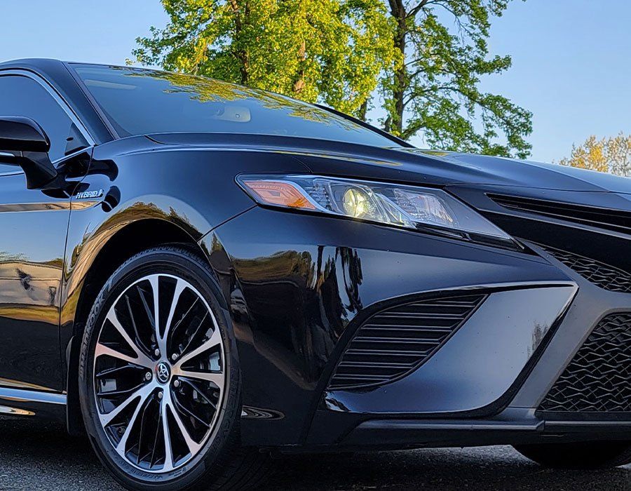A black toyota camry is parked in a parking lot.