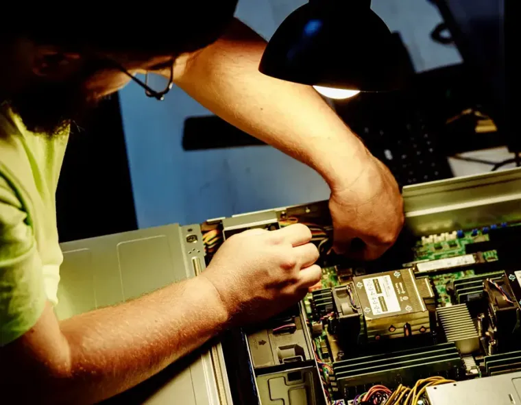 Technician working inside a desktop computer case