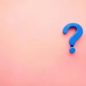 Blue question mark on a pink gradient background