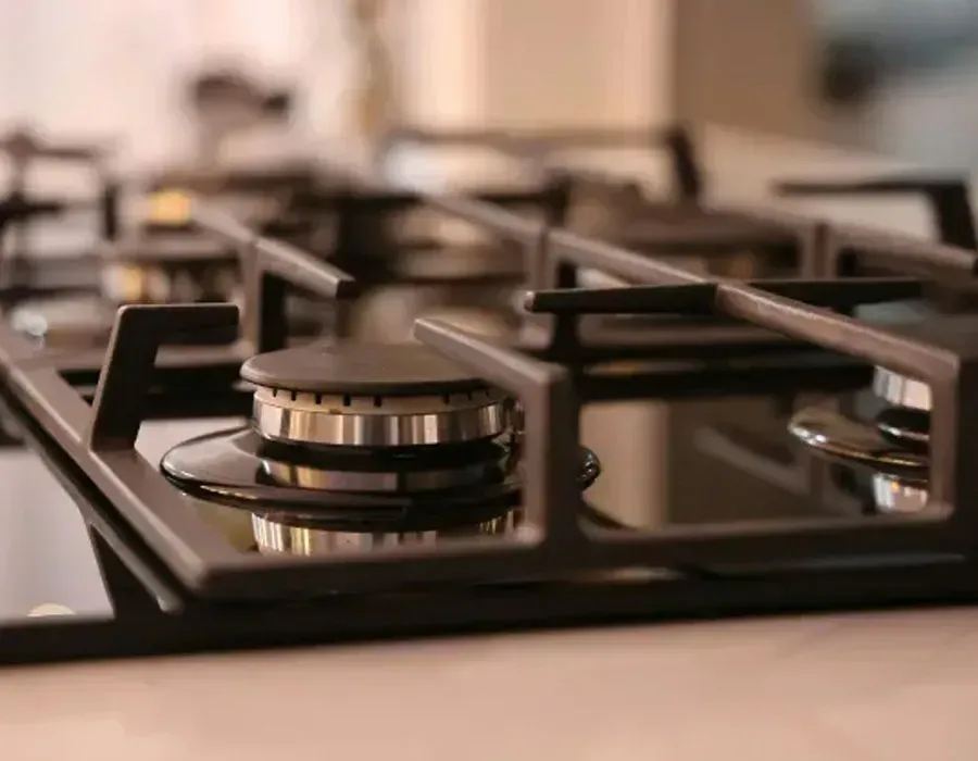 Close-Up of A Black Gas Stovetop with Metal Burner Knobs and Grates — Advanced Appliances Services in Richmond Hill, GA