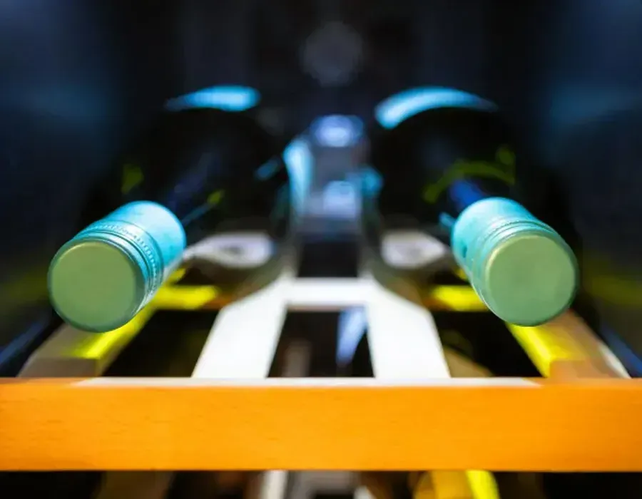 Foosball table close-up with blue and yellow handles in a dimly lit setting
