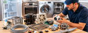 Person repairing a disassembled washing machine with tools and parts spread across a workbench