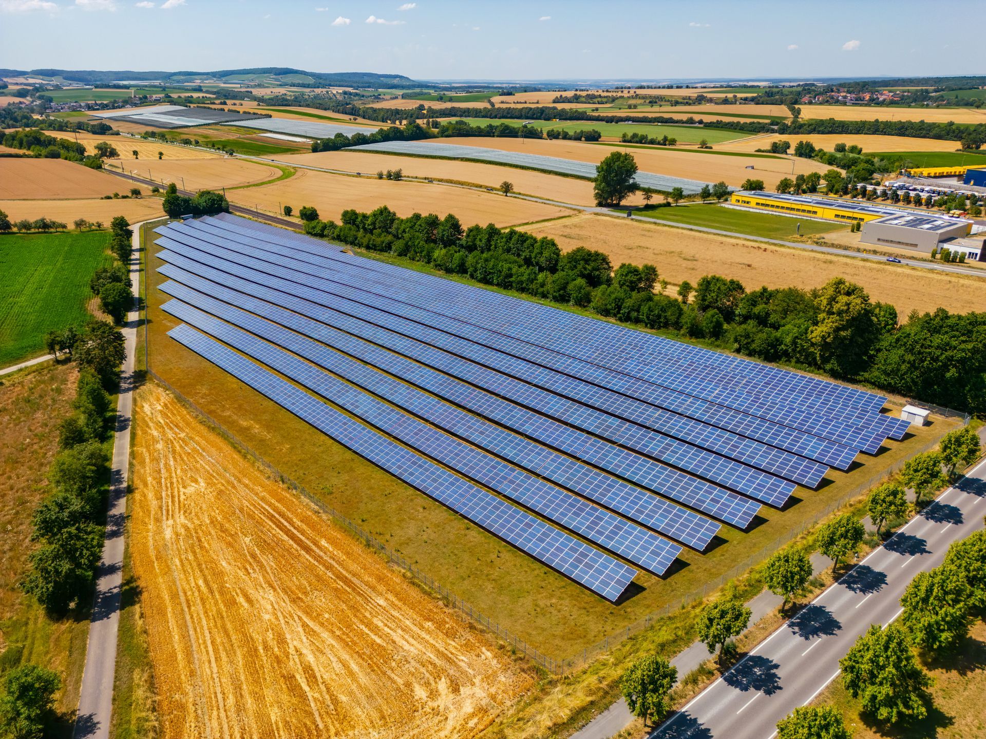 Pannelli solari in un campo vicino a una strada, che catturano la luce solare per generare energia pulita.
