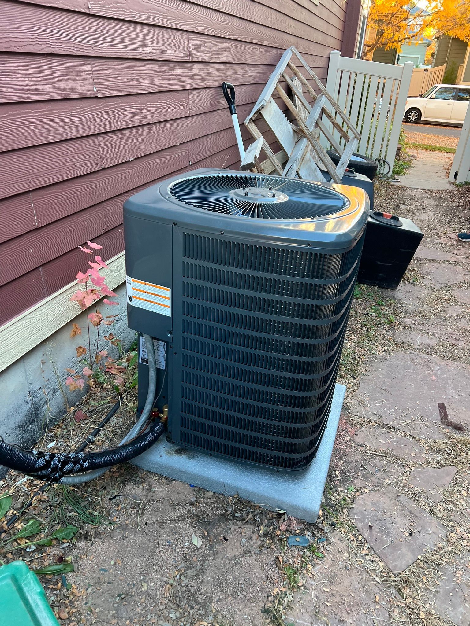Comfy Castle Heating and Air - A broken air conditioner is sitting on the side of a house.