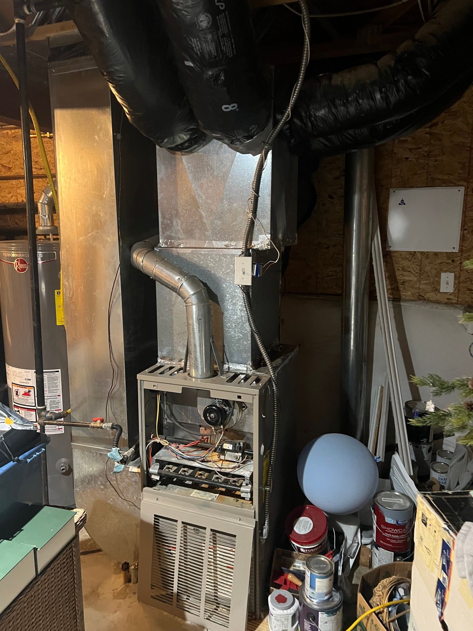 Comfy Castle Heating and Air - A furnace is sitting in a basement next to a water heater.